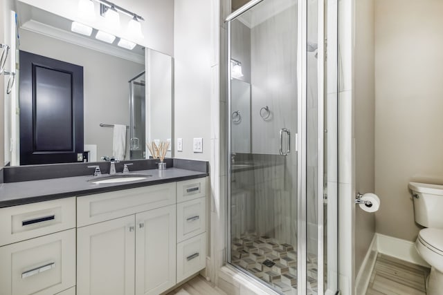 bathroom with an enclosed shower, vanity, toilet, and hardwood / wood-style floors