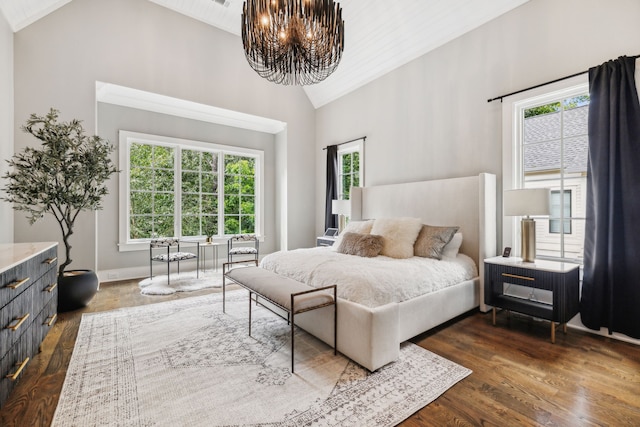 bedroom featuring dark wood-type flooring, high vaulted ceiling, and a notable chandelier