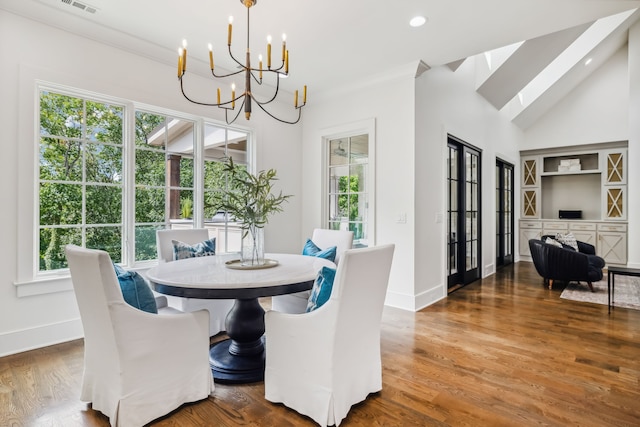 dining room featuring a wealth of natural light, wood-type flooring, and a notable chandelier