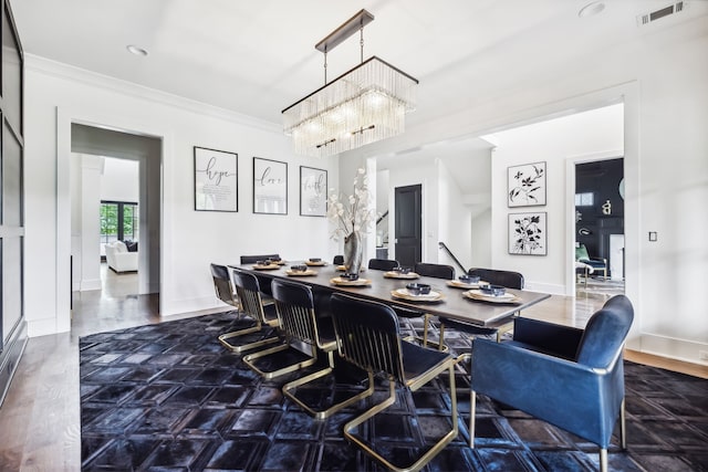 dining room featuring crown molding, dark wood-type flooring, and a chandelier