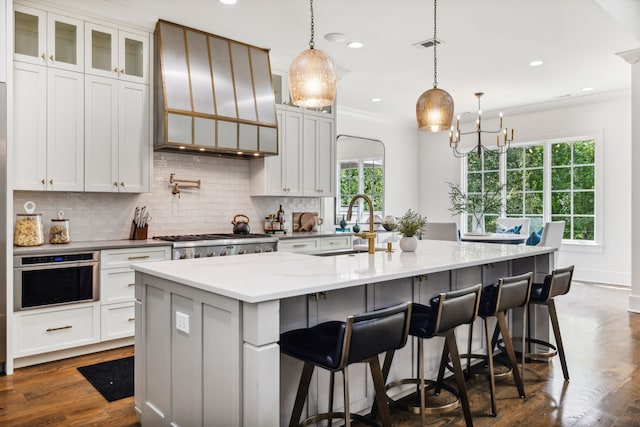 kitchen featuring white cabinets, sink, an island with sink, and appliances with stainless steel finishes