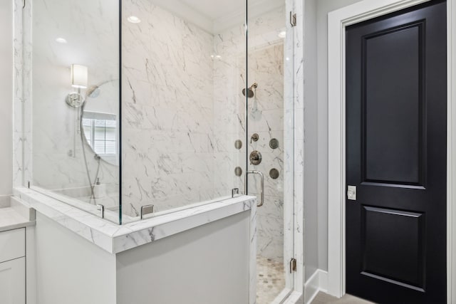 bathroom featuring a shower with door and ornamental molding