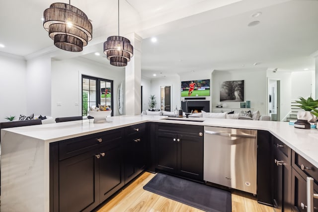 kitchen featuring kitchen peninsula, light stone counters, pendant lighting, dishwasher, and light hardwood / wood-style floors