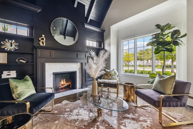 sitting room with high vaulted ceiling, wood ceiling, and a high end fireplace