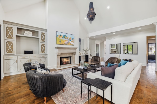 living room featuring wood-type flooring, high vaulted ceiling, and an inviting chandelier