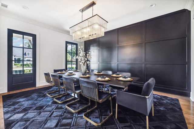 dining area featuring crown molding, plenty of natural light, dark wood-type flooring, and a notable chandelier