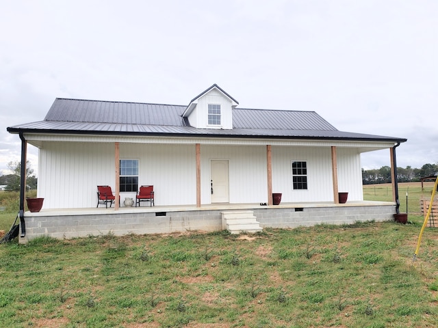 back of house with a lawn and covered porch