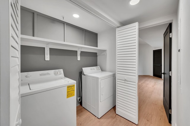 laundry room featuring light hardwood / wood-style flooring and washing machine and dryer