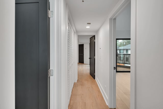 corridor with light hardwood / wood-style floors