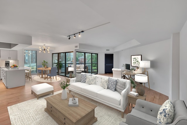 living room featuring a notable chandelier, light hardwood / wood-style flooring, and rail lighting