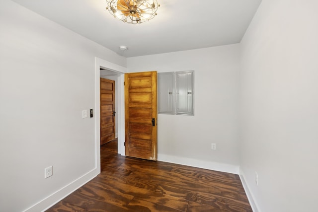 unfurnished bedroom featuring electric panel and dark hardwood / wood-style flooring