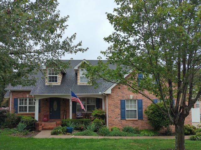 cape cod house with a porch and a front yard