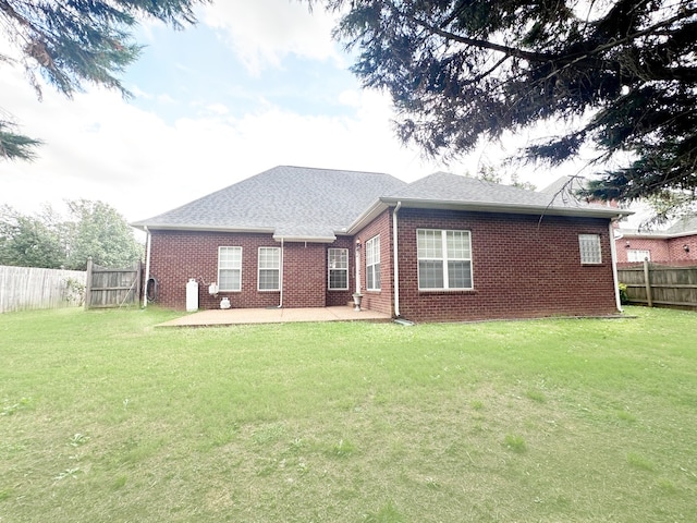 rear view of property featuring a yard and a patio