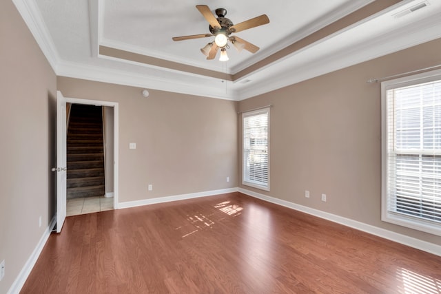 unfurnished room featuring hardwood / wood-style flooring, ornamental molding, ceiling fan, and plenty of natural light