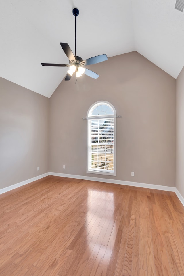 spare room with light wood-type flooring, vaulted ceiling, and ceiling fan