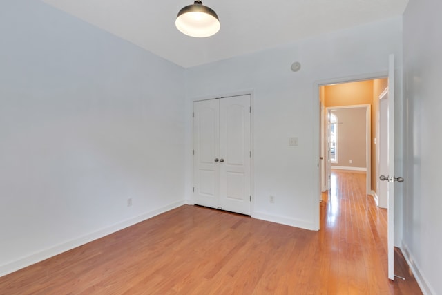 unfurnished bedroom featuring light wood-type flooring and a closet