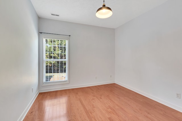 empty room featuring light wood-type flooring and a textured ceiling