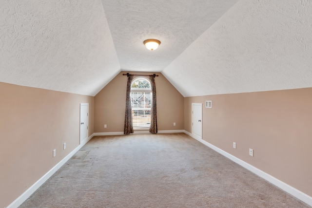 bonus room with light colored carpet, a textured ceiling, and lofted ceiling