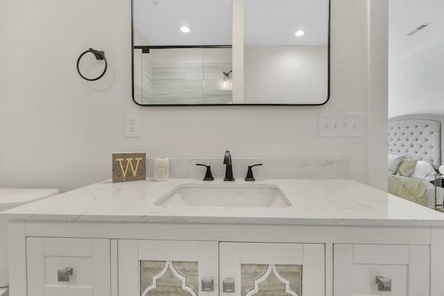 bathroom featuring vanity, an enclosed shower, and toilet