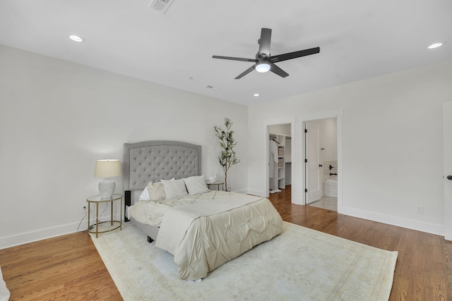 bedroom featuring wood-type flooring, ceiling fan, and a walk in closet