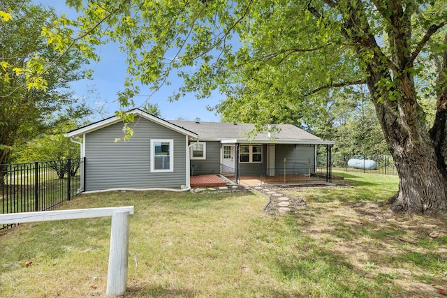 rear view of property featuring a lawn and a wooden deck