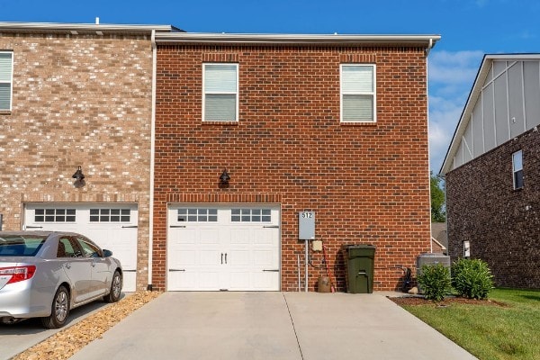 view of front of property featuring cooling unit and a garage