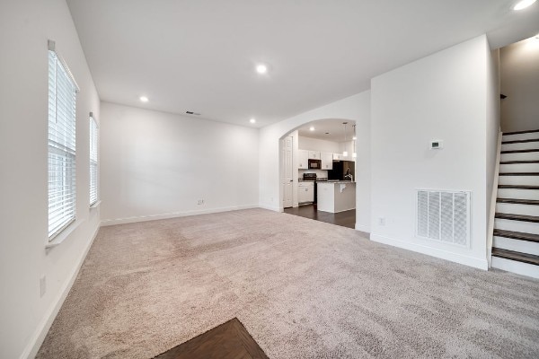 unfurnished living room featuring dark carpet