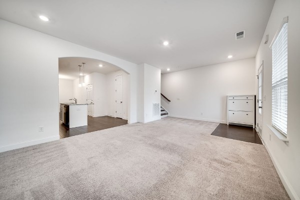 unfurnished living room with dark colored carpet