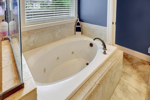 bathroom with a relaxing tiled tub and tile patterned floors