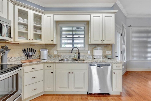 kitchen with sink, tasteful backsplash, stainless steel appliances, light wood-type flooring, and crown molding