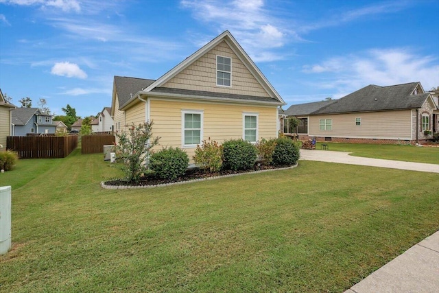 view of side of property featuring fence and a yard