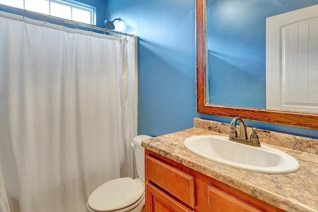 bathroom with a shower with shower curtain, vanity, and toilet