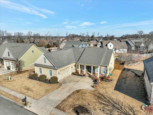 view of front facade featuring a residential view, driveway, a garage, and fence