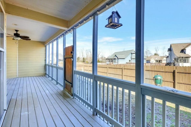 deck featuring a residential view, fence, and a ceiling fan