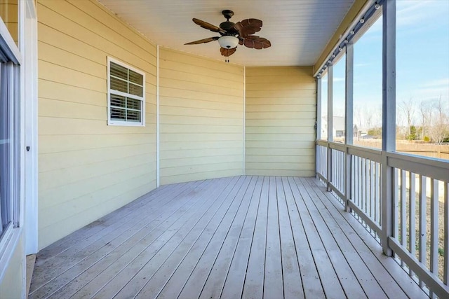 unfurnished sunroom with ceiling fan