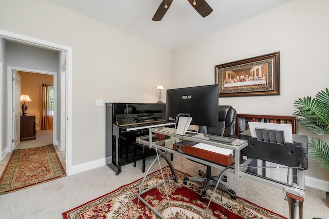 carpeted office space featuring ceiling fan