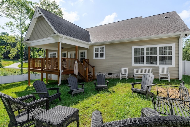 rear view of property with a wooden deck and a yard