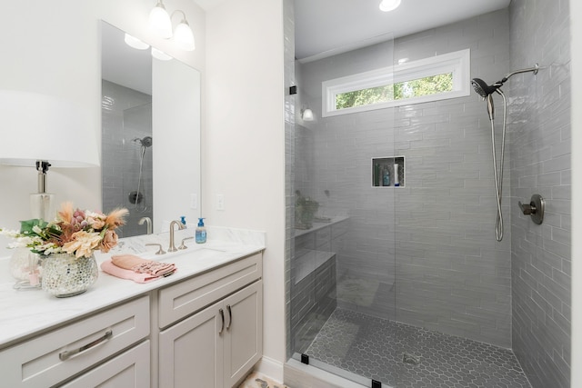 bathroom with vanity and a tile shower