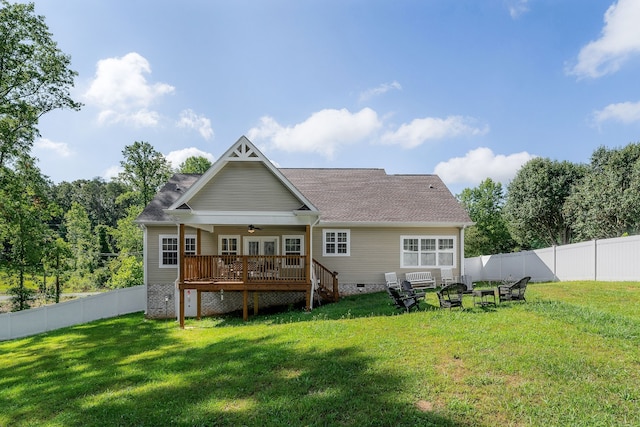 rear view of house with a wooden deck, ceiling fan, and a yard