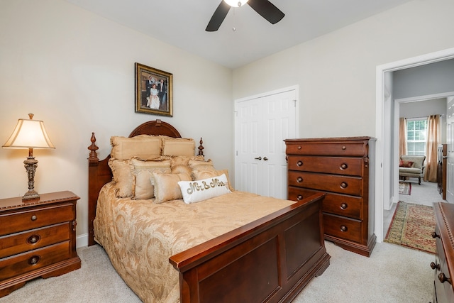 bedroom featuring light carpet, ceiling fan, and a closet