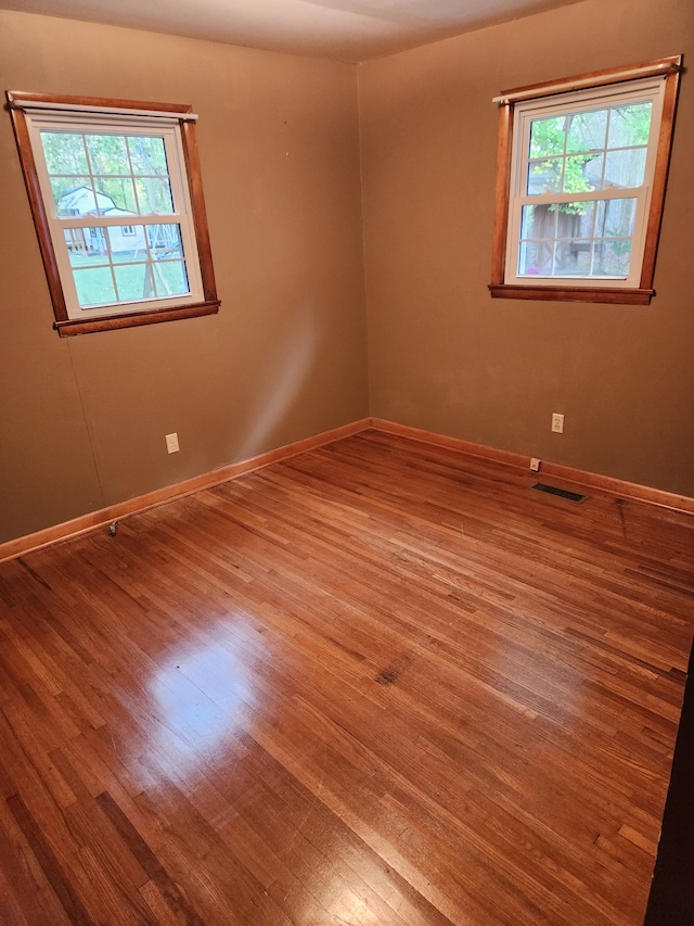 unfurnished room with a wealth of natural light and wood-type flooring