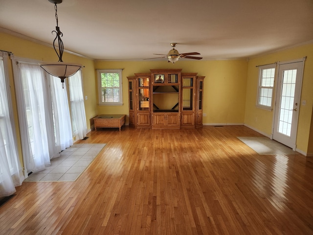 unfurnished living room featuring ceiling fan, light wood-type flooring, and ornamental molding