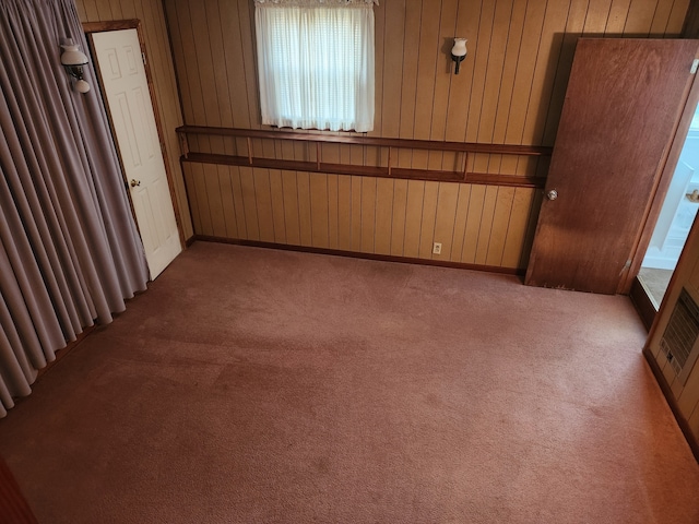 empty room with wooden walls and carpet