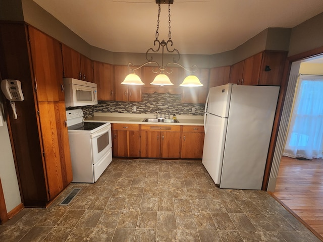 kitchen featuring sink, tasteful backsplash, light wood-type flooring, white appliances, and decorative light fixtures