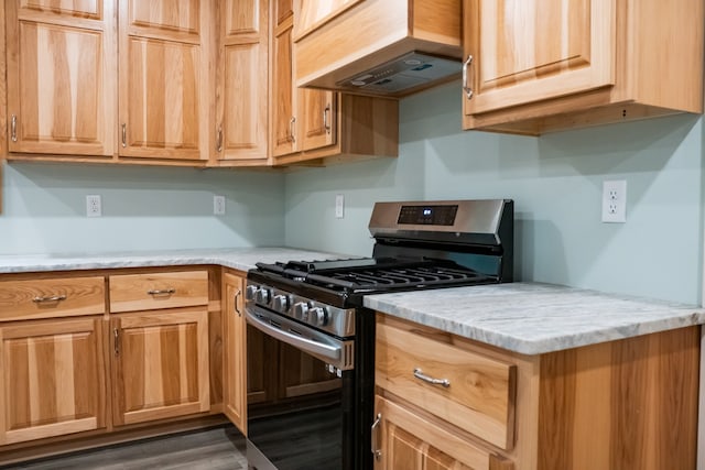 kitchen with gas stove, custom range hood, dark wood-type flooring, and light stone counters