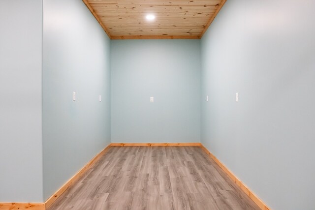 empty room with wooden ceiling and light hardwood / wood-style flooring