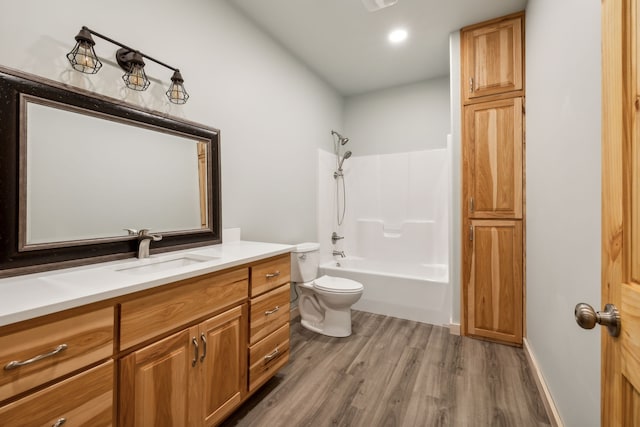 full bathroom with washtub / shower combination, vanity, toilet, and hardwood / wood-style flooring