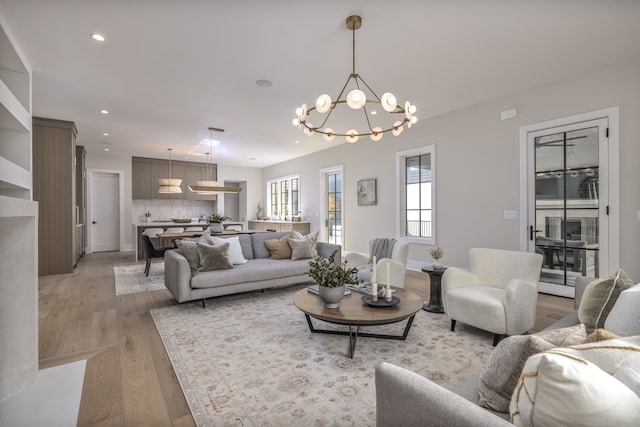 living room with light hardwood / wood-style flooring and a notable chandelier