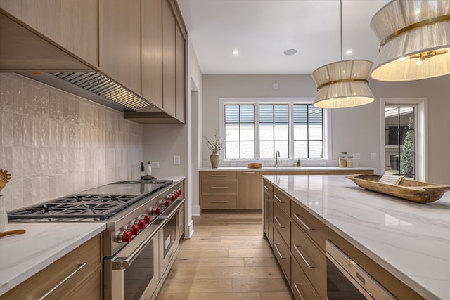 kitchen with range with two ovens, light stone countertops, hanging light fixtures, and tasteful backsplash