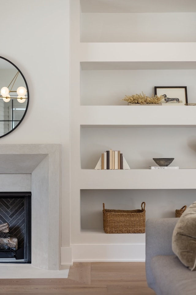 interior details featuring built in shelves and wood-type flooring